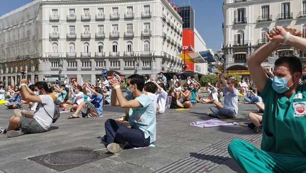 Residentes manifestándose sentados y atados en la Puerta del Sol (Madrid) - Sputnik Mundo