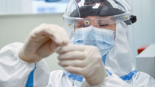 Especialista analiza un test para el coronavirus (archivo) - Sputnik Mundo