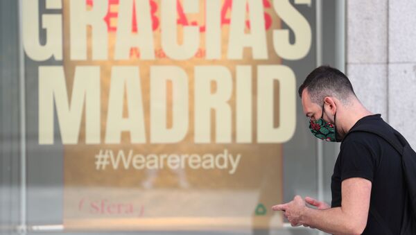 Un hombre pasa junto a una tienda que tiene un mensaje que dice Gracias Madrid. Foto de archivo.  - Sputnik Mundo