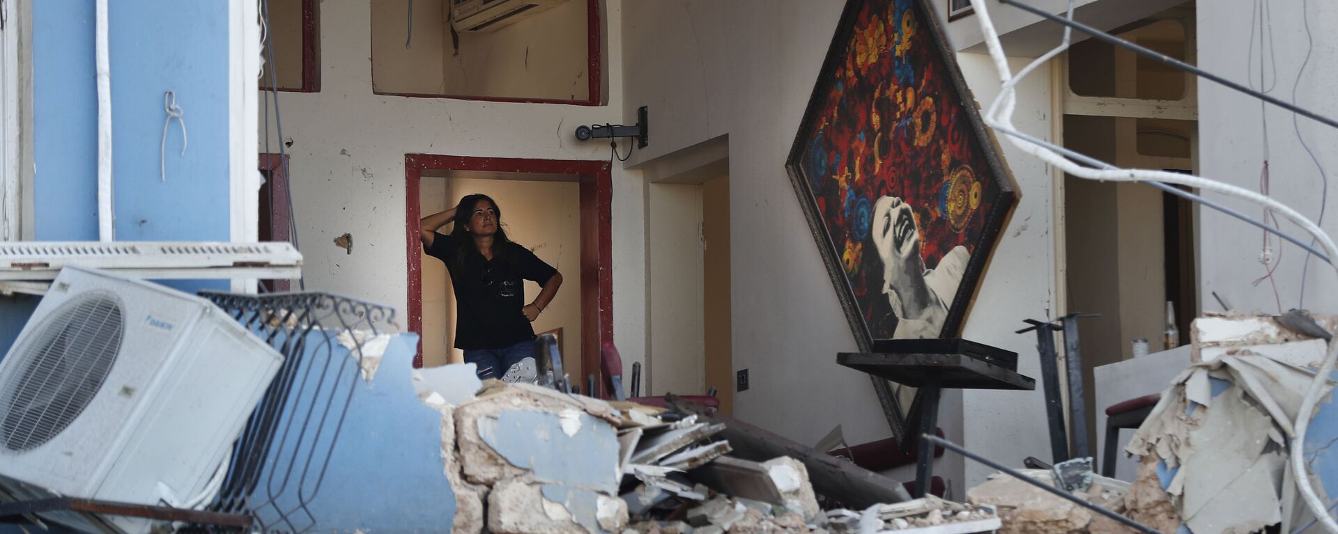 Una mujer se encuentra dentro de un restaurante dañado por la explosión en el puerto de Beirut, Líbano. 5 de agosto de 2020 - Sputnik Mundo, 1920, 03.08.2021