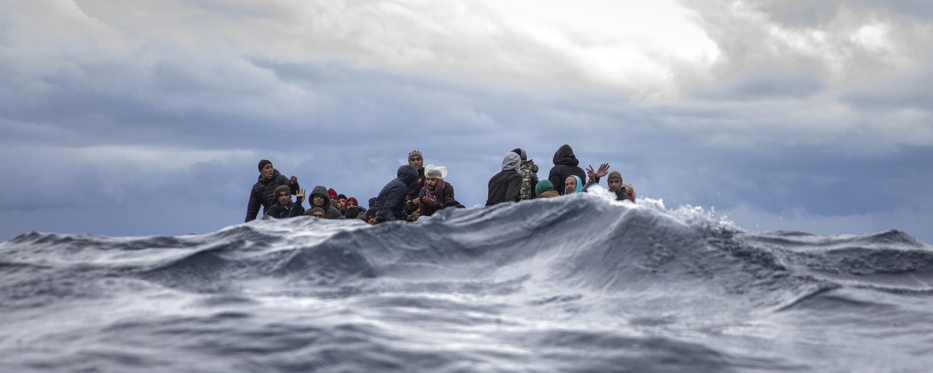 Inmigrantes en medio del mar Mediterráneo a punto de ser rescatados por la ONG española Open Arms. Enero 2020 - Sputnik Mundo, 1920, 20.07.2021