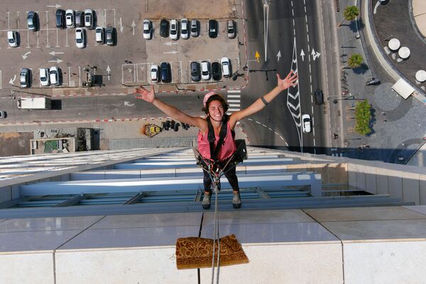 Специалист по мойке окон Ноа Толедо во время работы на высотном здании в Тель-Авиве, Израиль - Sputnik Mundo