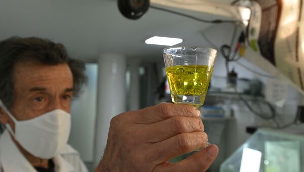 Farmacéutico boliviano con un vaso de dióxido de cloro - Sputnik Mundo