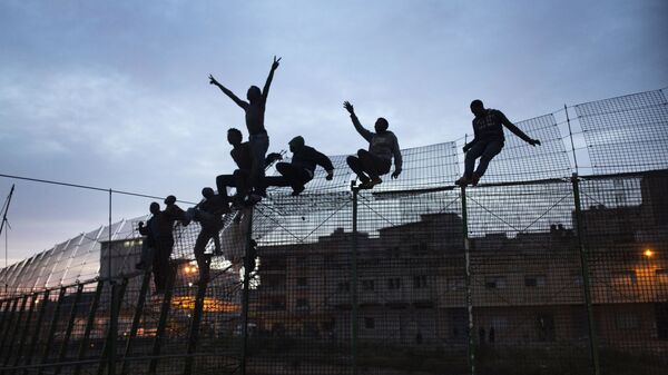 Inmigrantes subsaharianos intenta cruzar la valla de Melilla - Sputnik Mundo