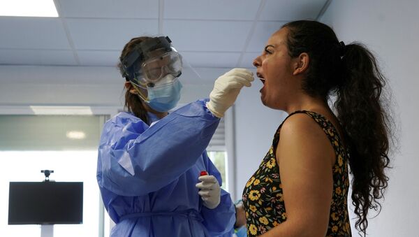 Una mujer haciéndose un test PCR en Madrid, España - Sputnik Mundo