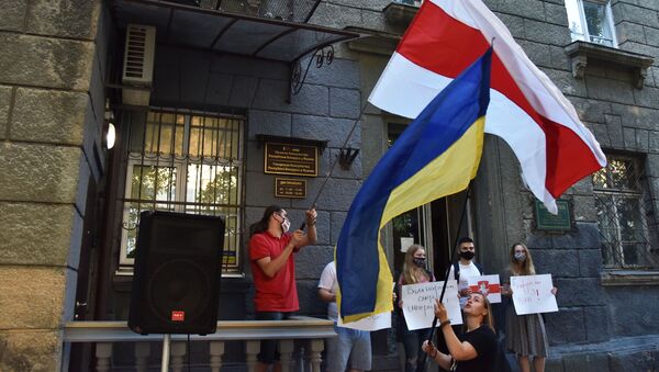 Una bandera de Ucrania y una bandera de la oposición bielorrusa en una manifestación en Kiev - Sputnik Mundo