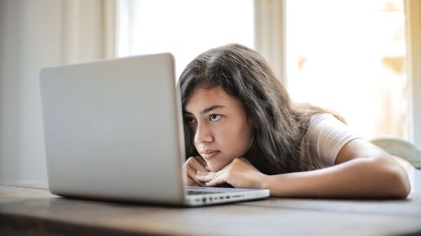 Una joven frente al ordenador, imagen ilustrativa - Sputnik Mundo