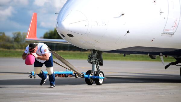 el atleta ruso Serguéi Agadzhanián establece un récord de fuerza al arrastrar un enorme avión en el aeropuerto de Kazán - Sputnik Mundo