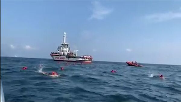 Migrantes saltan al agua del barco Open Arms - Sputnik Mundo