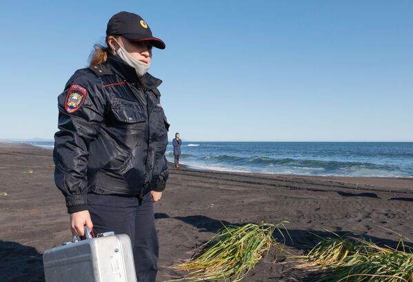 Сотрудник УМВД Камчатского края во время оперативно-разыскных мероприятий на месте предполагаемого происшествия на Халактырском пляже на Камчатке - Sputnik Mundo