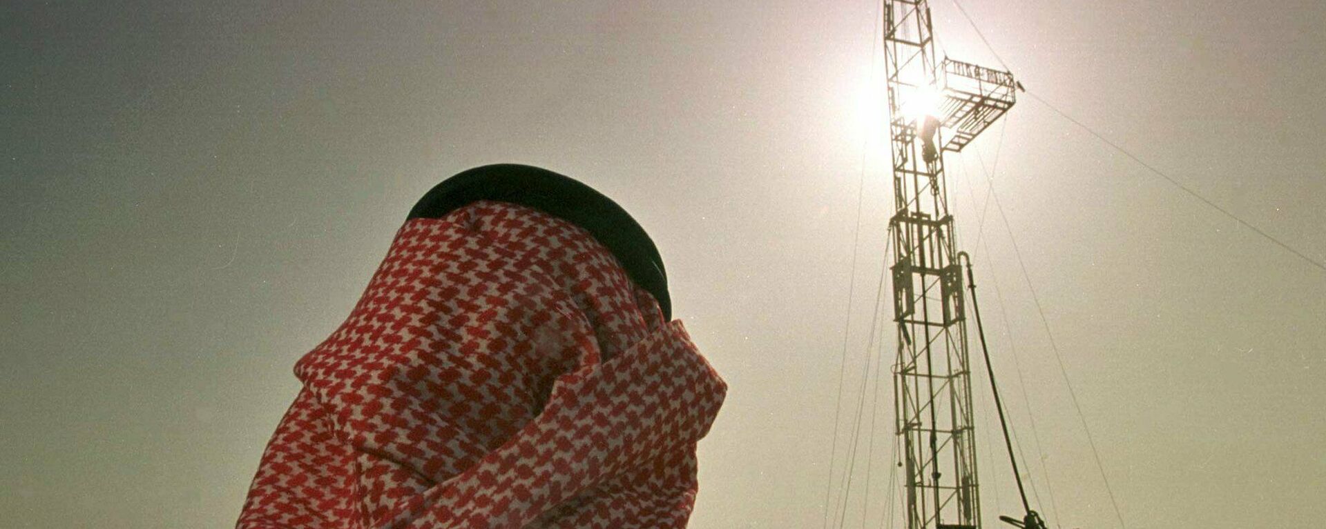 Un empleado de la compañía petrolera saudí Aramco observa el progreso de una plataforma situada en un yacimiento petrolero  - Sputnik Mundo, 1920, 31.10.2021