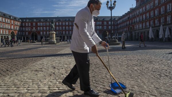 Un camarero con mascarilla limpiando en una de las terrazas de la Plaza Mayor de Madrid - Sputnik Mundo