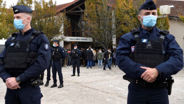 Varios policías están de guardia cerca de la entrada a la escuela en Conflans-Sainte-Honorine - Sputnik Mundo