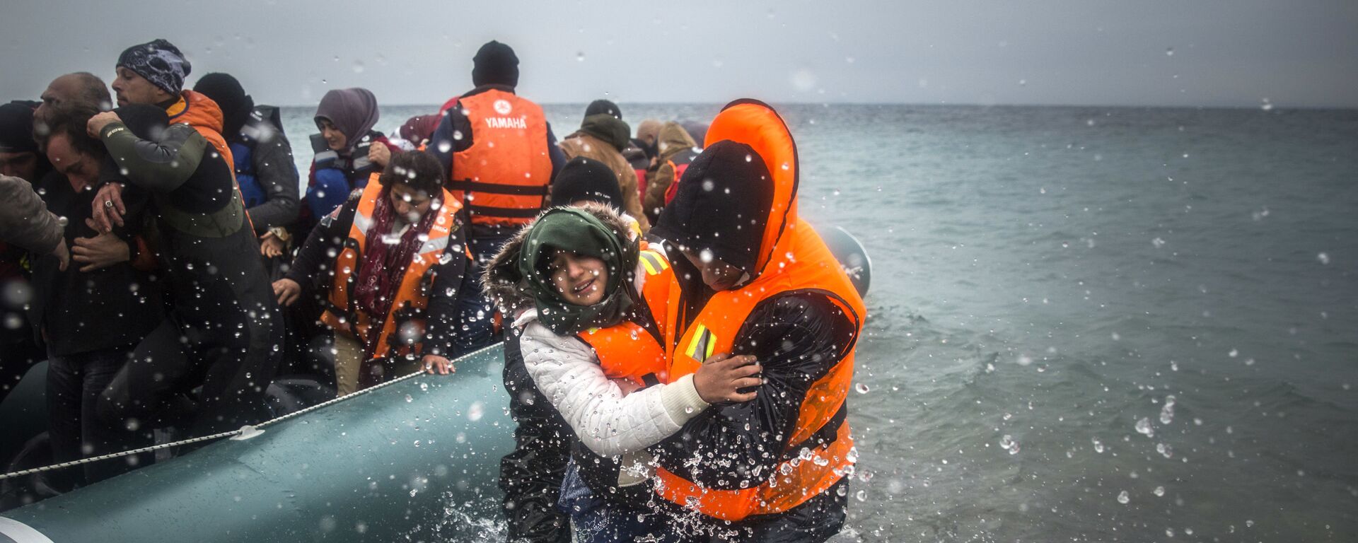 Refugiados y migrantes desembarcan en una playa después de cruzar una parte del mar Egeo desde Turquía hasta la isla griega de Lesbos - Sputnik Mundo, 1920, 21.06.2022