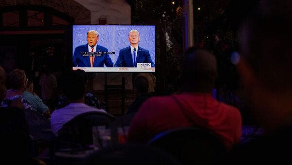 Unas personas siguen el último debate entre los candidatos Joe Biden y Donald Trump antes de las elecciones presidenciales de EEUU - Sputnik Mundo