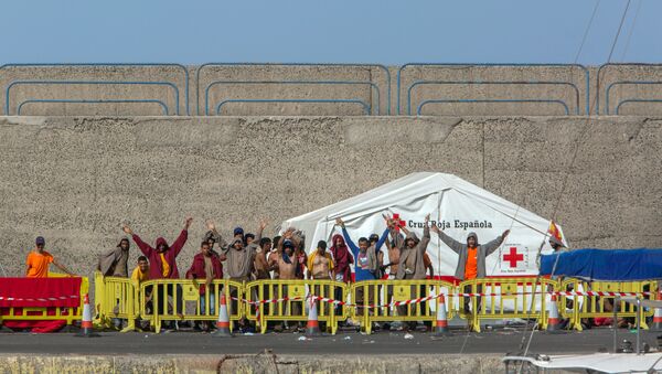Migrantes gritan libertad junto a las tiendas de la Cruz Roja en las que se alojan unos 400 migrantes en El Puerto de Arguineguín (Gran Canaria) - Sputnik Mundo