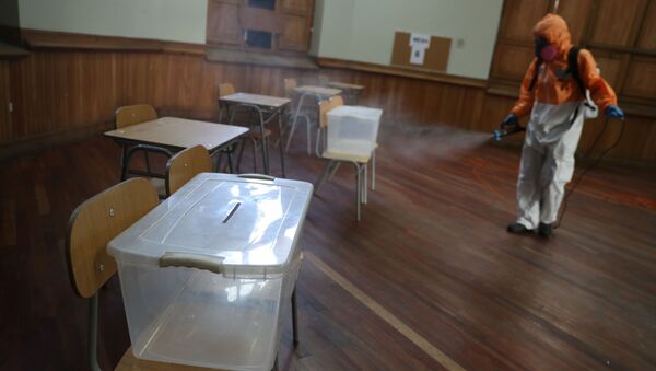 Desinfectan un centro electoral en Santiago de Chile - Sputnik Mundo