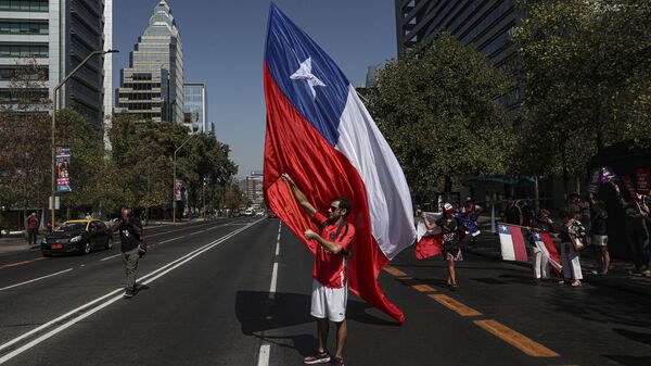 Un manifestante con la bandera de Chile - Sputnik Mundo
