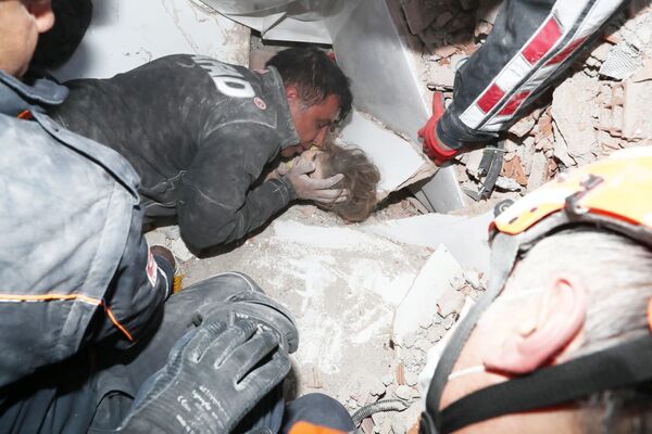Спасатели вытаскивают ребенка из-под завала в результате землетрясения в Измире, Турция - Sputnik Mundo