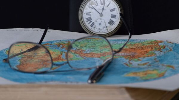 Unas gafas en un mapa del mundo (imagen referencial) - Sputnik Mundo