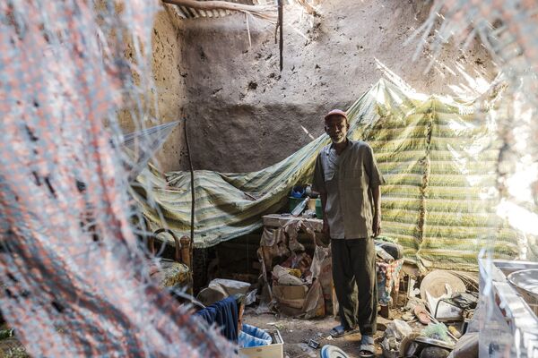 Мужчина стоит в доме, пострадавшем в результате обстрела, в Хумере, Эфиопия - Sputnik Mundo
