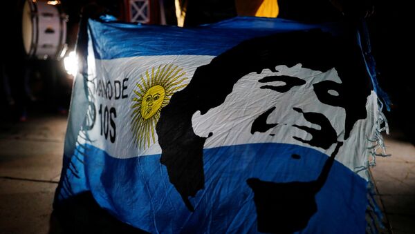 Una bandera de Argentina con el retrado de Maradona - Sputnik Mundo