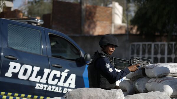  Un policía mexicano está de guardia detrás de un parapeto de sacos con arena en México - Sputnik Mundo