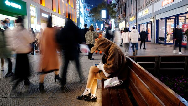 Девушка с мобильником в главном торговом районе Уханя через год после начала вспышки коронавируса, Китай - Sputnik Mundo