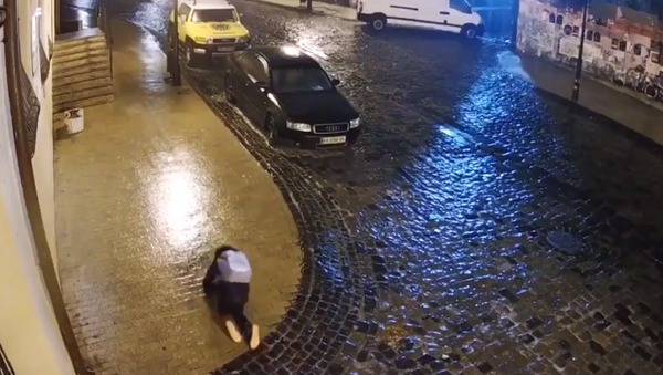 Una ucraniana intenta cruzar una calle helada en Kiev - Sputnik Mundo