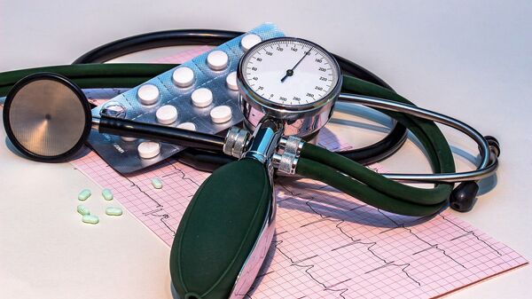 Un aparato para medir la presión arterial, unas pastillas y un gráfico de cardiograma  - Sputnik Mundo