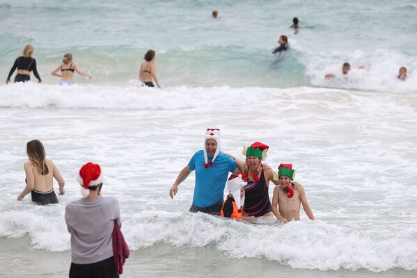 En Navidad la gente se toma fotos en una playa de Sidney, Australia. - Sputnik Mundo