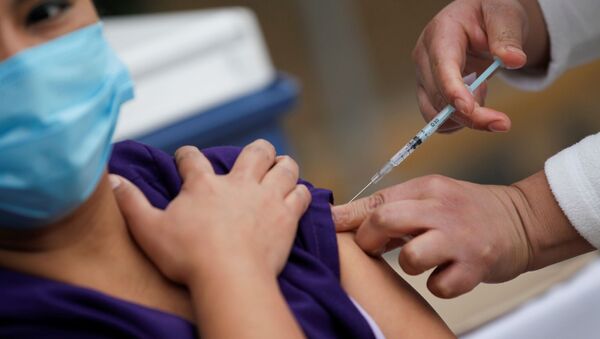 Una persona recibe la vacuna de Pfizer contra el COVID-19 en México - Sputnik Mundo