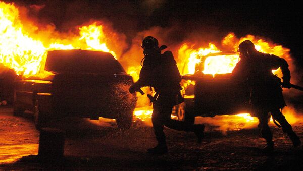 Bomberos intentan extinguir el fuego en autos prendidos por vándalos en los suburbios de Estrasburgo (Francia), el 1 de enero del 2005 - Sputnik Mundo