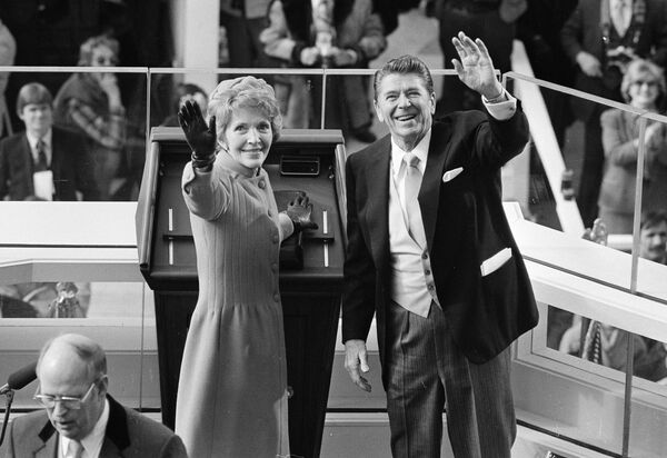 El republicano Ronald Reagan tomó la posesión como el 40.º presidente de EEUU el 20 de enero de 1981. La ceremonia de investidura fue la primera en realizarse en el Frente Occidental del Capitolio —el edificio del Congreso estadounidense—, en donde se realizan hasta los días actuales. A pocos días de cumplir 70 años en el momento de su investidura, Reagan se convirtió en la persona de mayor edad en asumir la presidencia de EEUU hasta aquel momento.En la foto: el presidente Ronald Reagan y la primera dama Nancy Reagan saludan a los espectadores en el edificio del Capitolio luego de la ceremonia de toma de posesión, el 20 de enero de 1981. - Sputnik Mundo