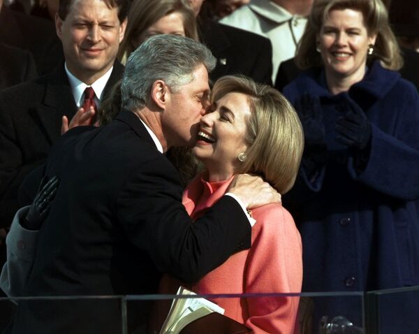 Pese al escándalo Lewinsky en 1998, lo cual culminó en un intento fallido de destituir a Clinton de la Presidencia, el demócrata logró reelegirse. Su segunda ceremonia de toma de posesión, el 20 de enero de 1997, fue la primera en transmitirse en directo por internet.En la foto: el presidente Bill Clinton besa a su esposa, Hillary Clinton, después de jurar su segundo mandato.  - Sputnik Mundo