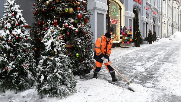 Un trabajador limpia de nieve una calle de Moscú  - Sputnik Mundo