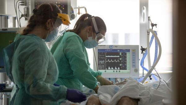 Trabajadores sanitarios asisten a un paciente con COVID-19 en una de las unidades de cuidados intensivos (UCI) del Hospital Universitario de Torrejón - Sputnik Mundo