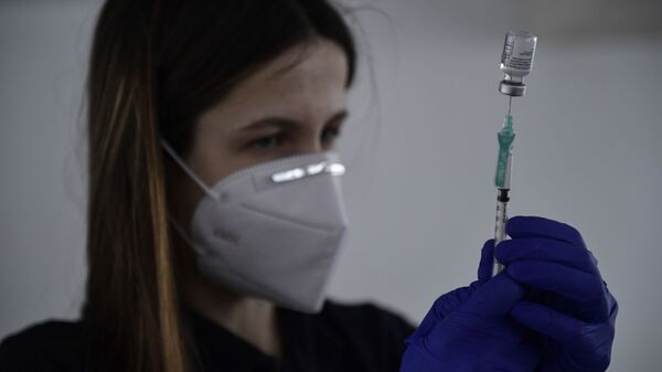 Imagen referencial de una sanitaria suministrando la vacuna de Pfizer en España - Sputnik Mundo