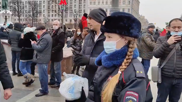 Una policía reparte mascarillas entre los manifestantes en Moscú - Sputnik Mundo