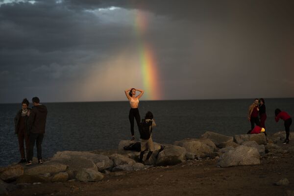 Unas personas posan frente a un arcoíris, luego de una tormenta en Barcelona (España), el 30 de enero. - Sputnik Mundo
