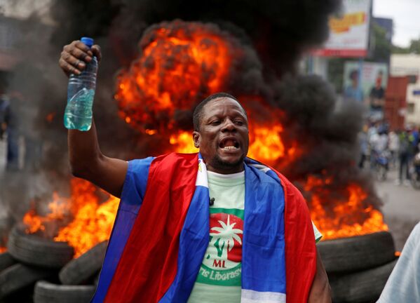 Un manifestante sostiene una botella con gasolina en medio de las protestas contra el Gobierno de Jovenel Moise, en enero de 2021. - Sputnik Mundo