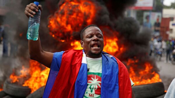 Un participante de protestas en Haití - Sputnik Mundo