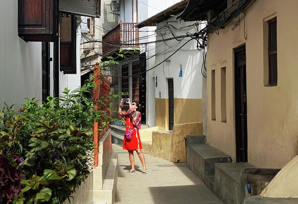 Una turista toma una foto en una calle de Zanzíbar. - Sputnik Mundo