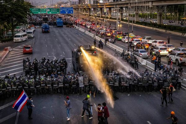 La Policía en la ciudad de Bangkok usa cañones de agua para dispersar a los manifestantes que se dirigen hacia la residencia del primer ministro de Tailandia, Prayut Chan-O-Cha. - Sputnik Mundo