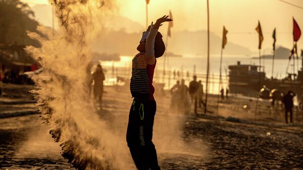 Un niño juega con arena en una playa en la India - Sputnik Mundo
