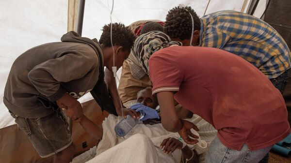 Unas enfermeras dan agua a un anciano de Tigray que sufre diabetes y deshidratación  - Sputnik Mundo