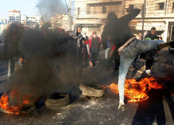 Los manifestantes bloquean una carretera con neumáticos en llamas durante una protesta contra la caída de la libra libanesa en Sidón, Líbano. - Sputnik Mundo