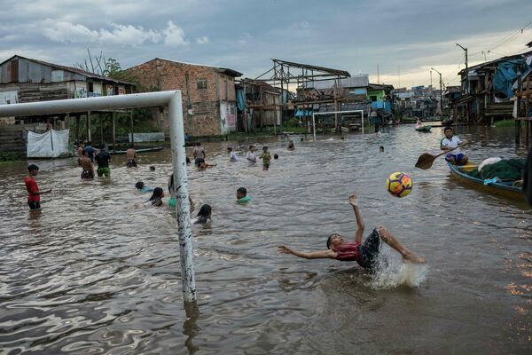 Unos niños juegan en un distrito inundado de la ciudad de Iquitos, en Perú. - Sputnik Mundo