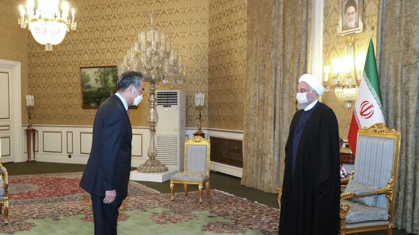El ministro de Exteriores de China, Wang Yi, y el presidente de Irán, Hasán Rohaní - Sputnik Mundo