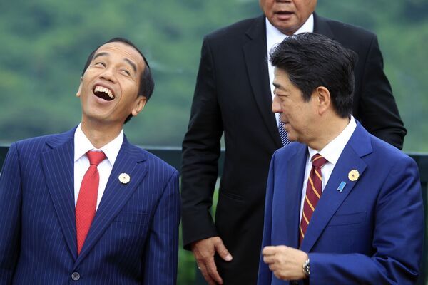 El presidente indonesio, Joko Widodo (izquierda), y el entonces primer ministro japonés, Shinzo Abe, se fotografían para una foto de familia en la cumbre de la APEC en Danang, Vietnam, 2017.  - Sputnik Mundo